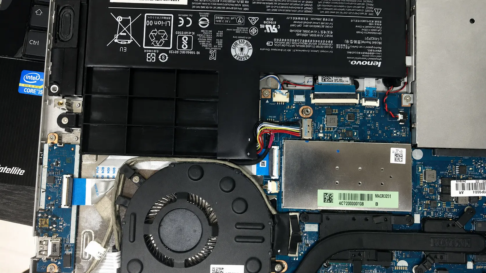 Interior de una notebook con la batería, su cableado y la zona de alimentación de la motherboard expuestos